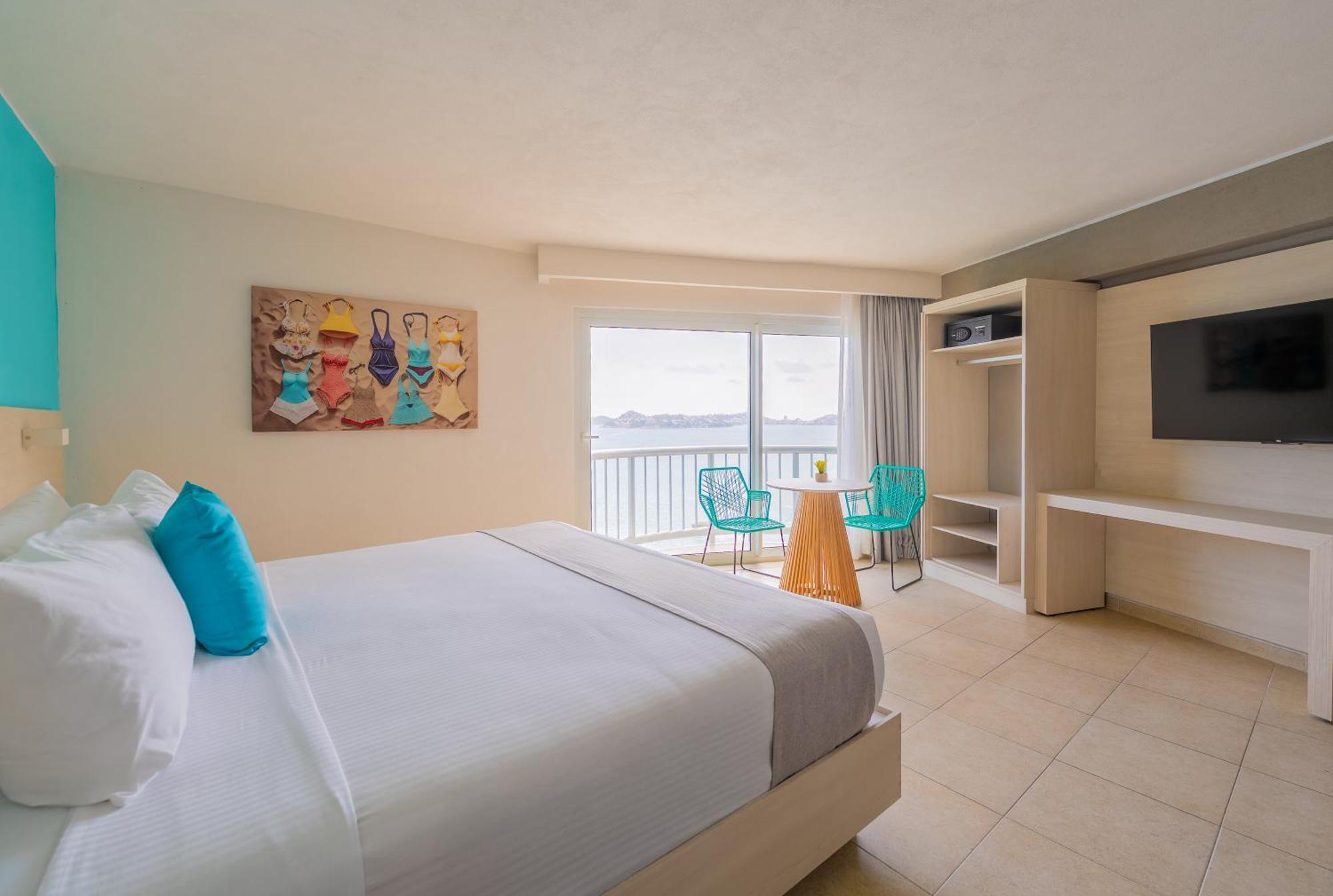Quarto superior com cama king-size e vista do mar